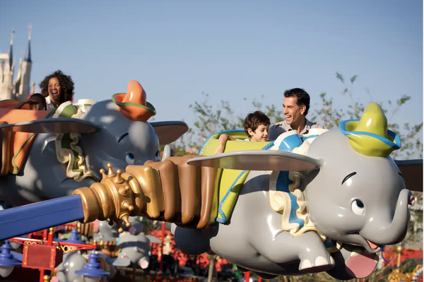 pasażerowie jeżdżący Dumbo latającym słoniem w parku magicznego królestwa Walta Disneya